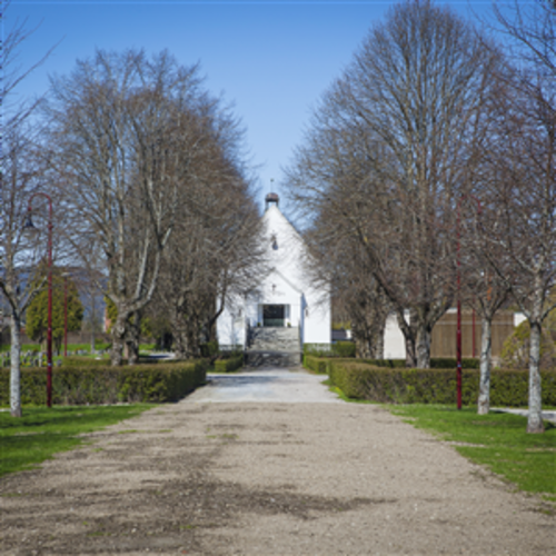 Nordre gravlund kapell. Veien fram imot og trær ved siden av veien