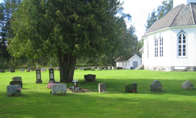 Kilebygda kirke og kirkegård med gravminner. Stort tre
