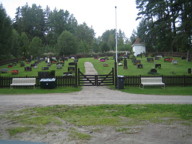 Valebø kirkegård. Veien går forbi, porten med benk på hver side og gjerdet rundt.