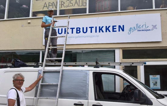 NY BUTIKK: Frivillig medarbeider Narve Thorset på Ål setter opp skiltet til Normisjons tiende gjenbruksbutikk på Evjens Minne. FOTO: Normisjon