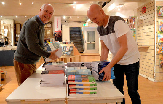 MOTBAKKE: Eier Hans Petter Foss (til venstre) og butikksjef Øyvind Hjemdal i Bok & Media i Akersgata har hendene fulle med bøker, men færre kunder i butikken enn før. Foto: Stein Gudvangen, KPK.