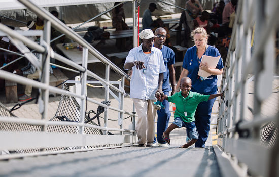 HÅP: Det stråler forventning av ansiktet til Mohammed som er på vei opp landgangen til operasjonsstua på «African Mercy» i Guinea i Vest-Afrika. Foto: Mercy Ships.