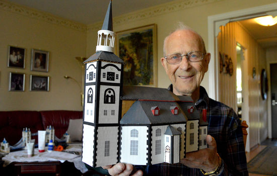 KIRKEBYGGER: Leif Carlsen har laget modeller av både kjente og mindre kjente kirkebygninger. Her holder han en modell av Røros kirke, også kjent som Bergstadens Ziir. Foto: Stein Gudvangen, KPK.