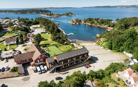OVERTAR: Frikirken blir ny eier for Kristiansand Folkehøgskole som ligger vakkert til ut mot Sørlandets skjærgård. Foto: Kristiansand Folkehøgskole.