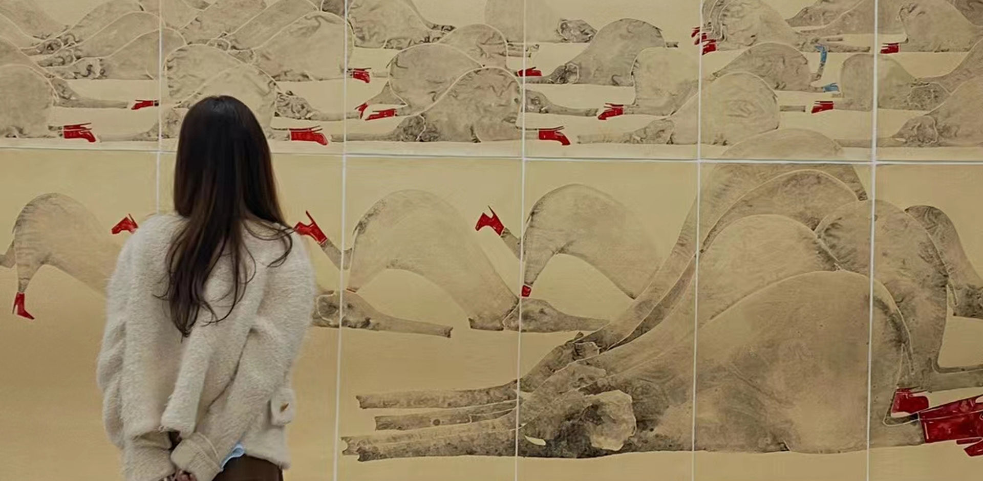 En besøkende på utstillingen «Red High Heels» betrakter et verk av Yang Hui.