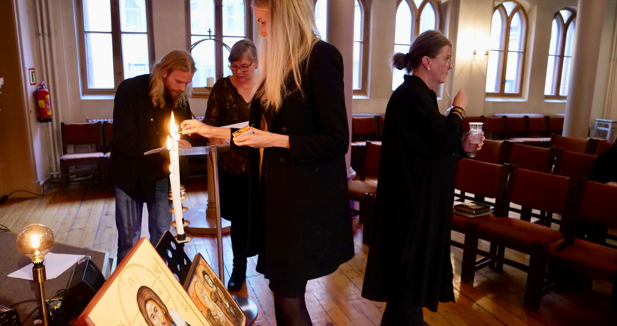 Marie Veggeland tenner lys mens Oskar Nordbø og Merete Finnseth går gjennom liturgien.
