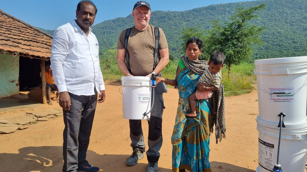 Øyvind Dovland har demonstrert hvordan vannfiltrene fungerer, og Prasanth Halonen og folk fra landsbyen følger spent med.