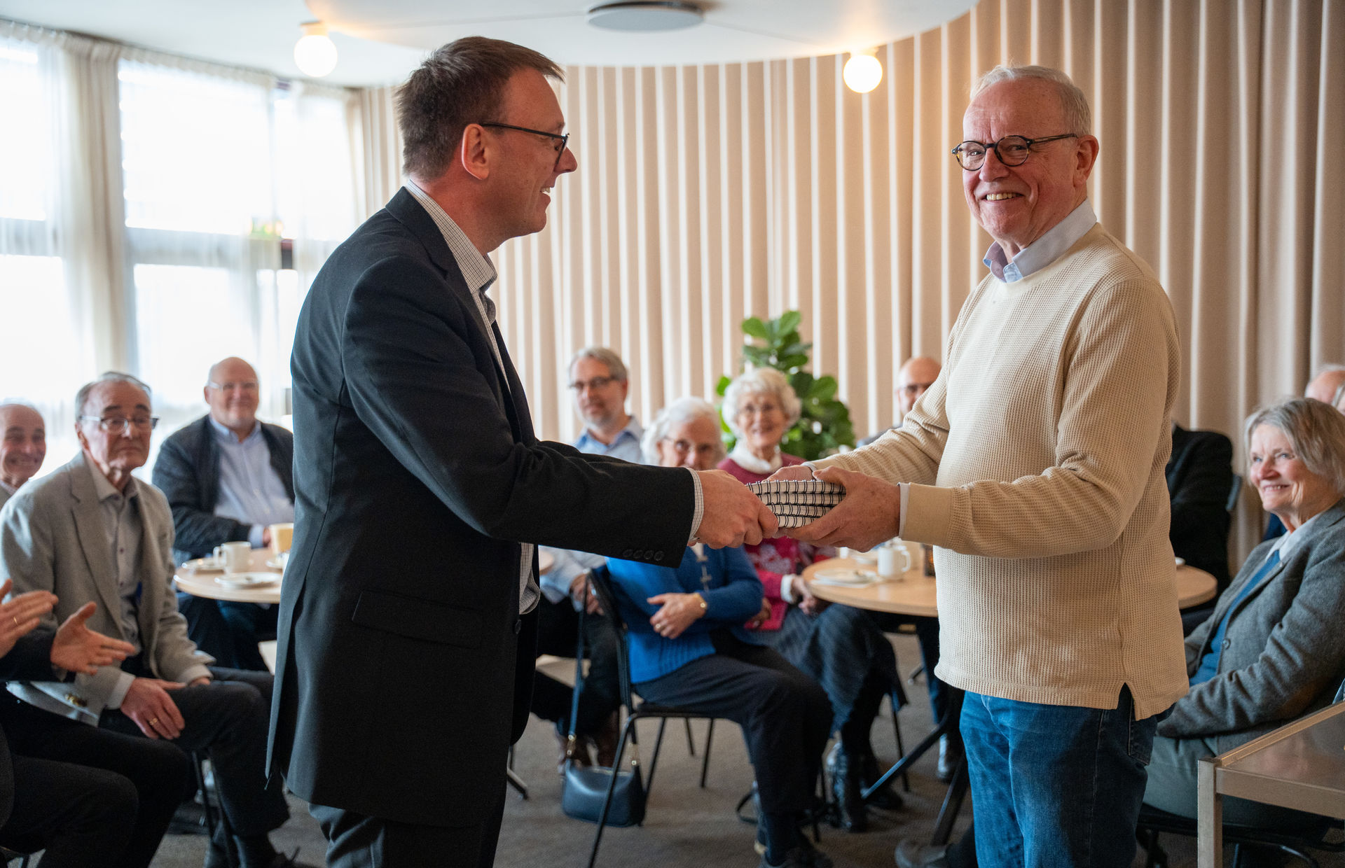 Ragnar Osnes (t.h.) overrekker fire-binds verket til Fjellhaugs prorektor Kenneth F. Ellefsen