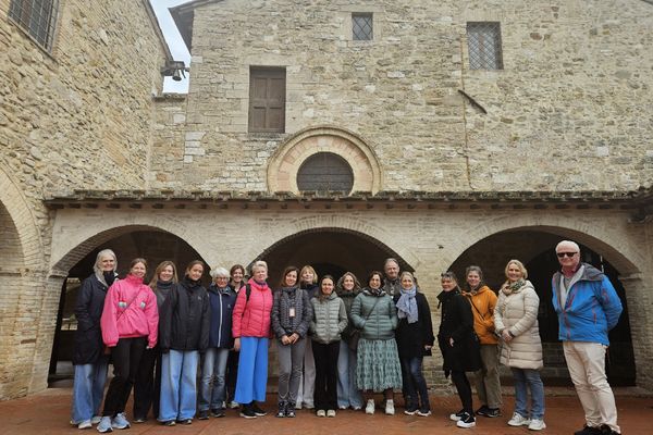 Ansatte, frivillige, styreleder og guide samlet samlet foran san damiano