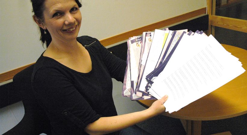 Kontorsekretær Anne Austgulen med de mange svarene som er kommet - både på e-post og i posten.