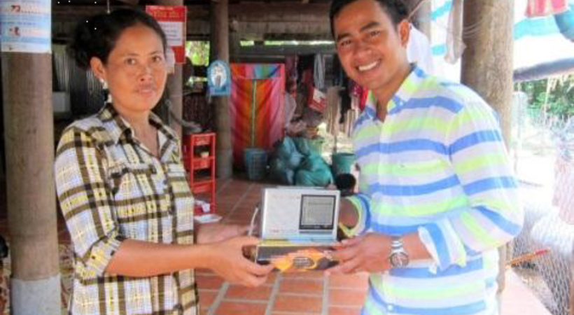Radiolytter Sok Nai får overrekt en radio fra en i radioteamet på Kambodsja.